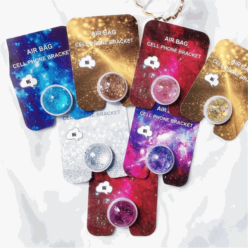 Colorful quicksand phone holders with sparkly galaxy designs and round grips on display cards