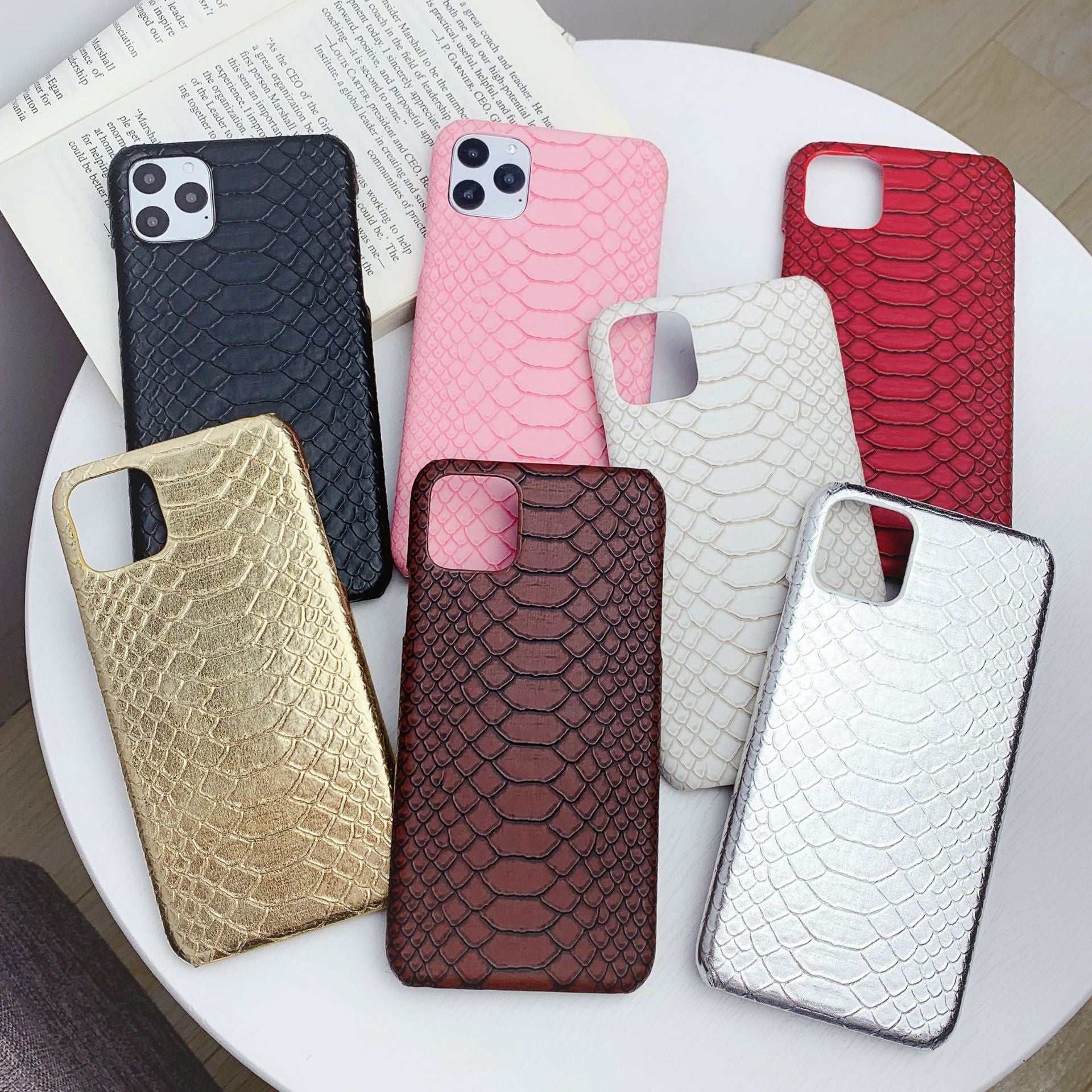Collection of snakeskin print phone cases in various colors for iPhone models with fall protection